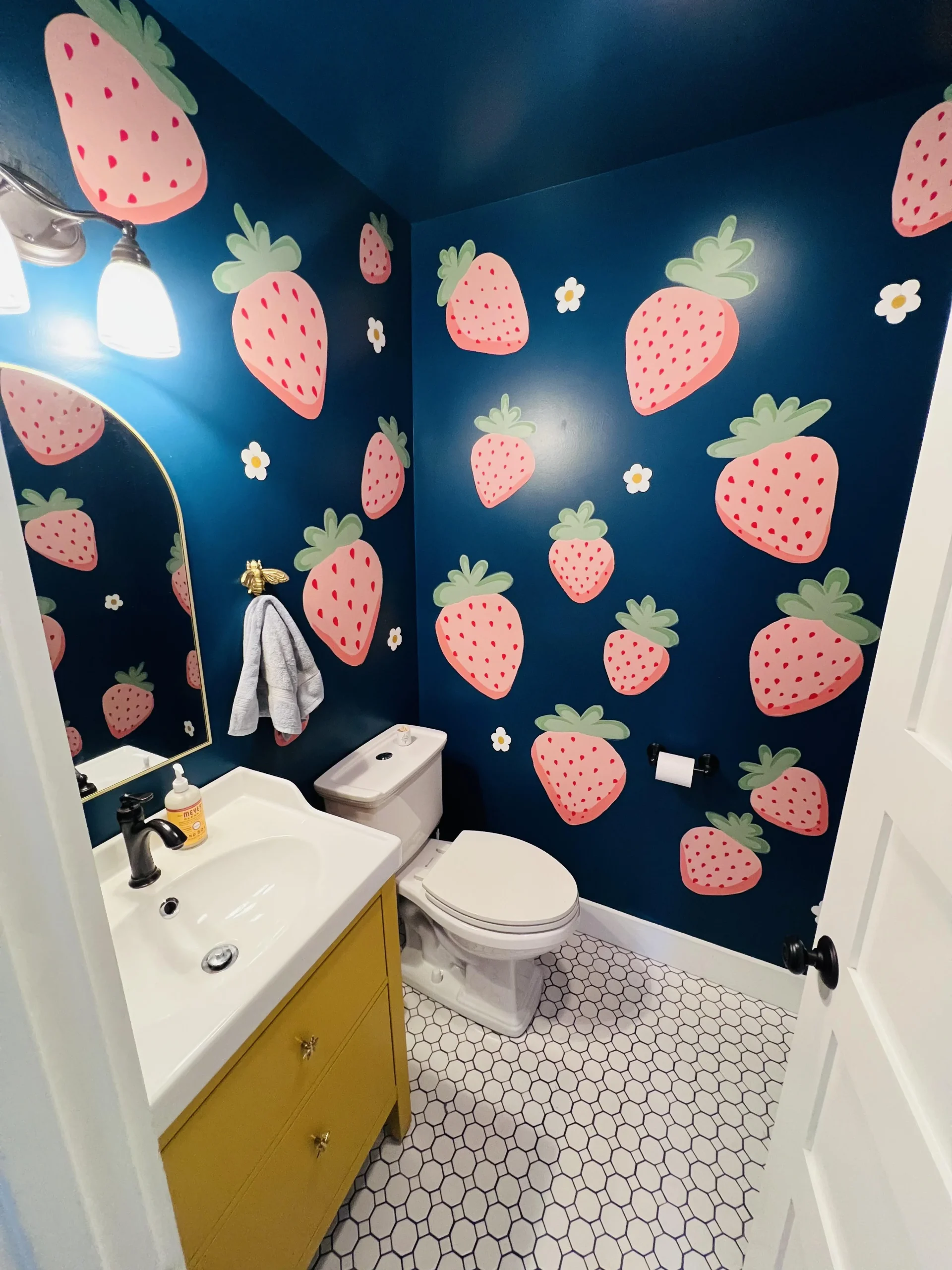 Idee bagno originale: fragole dipinte a mano e blu profondo in un bagno di servizio di pochi metri