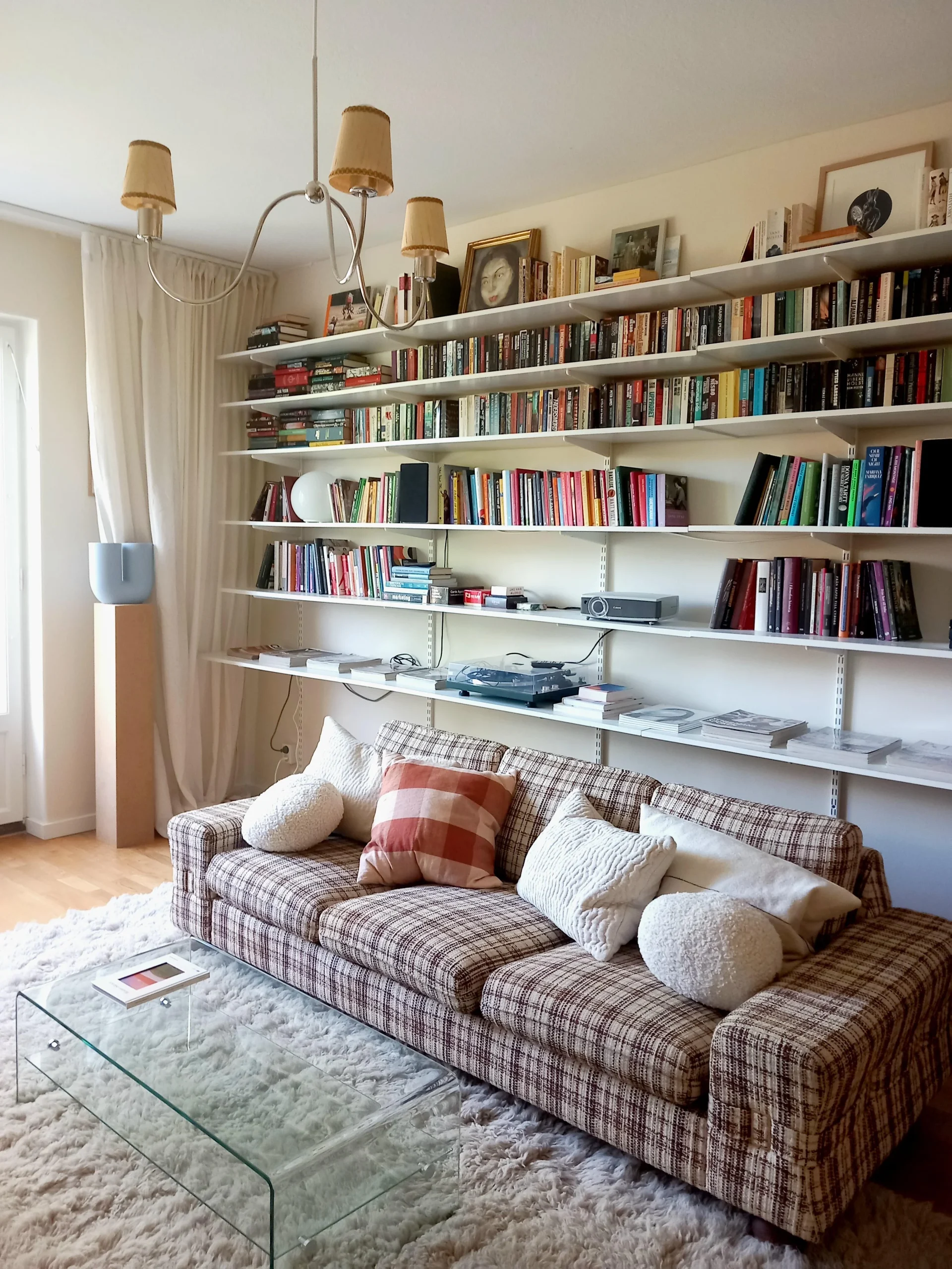 Abbinare vintage e moderno in un soggiorno scandinavo: cromo, libreria a parete e un tocco di rosso Falun