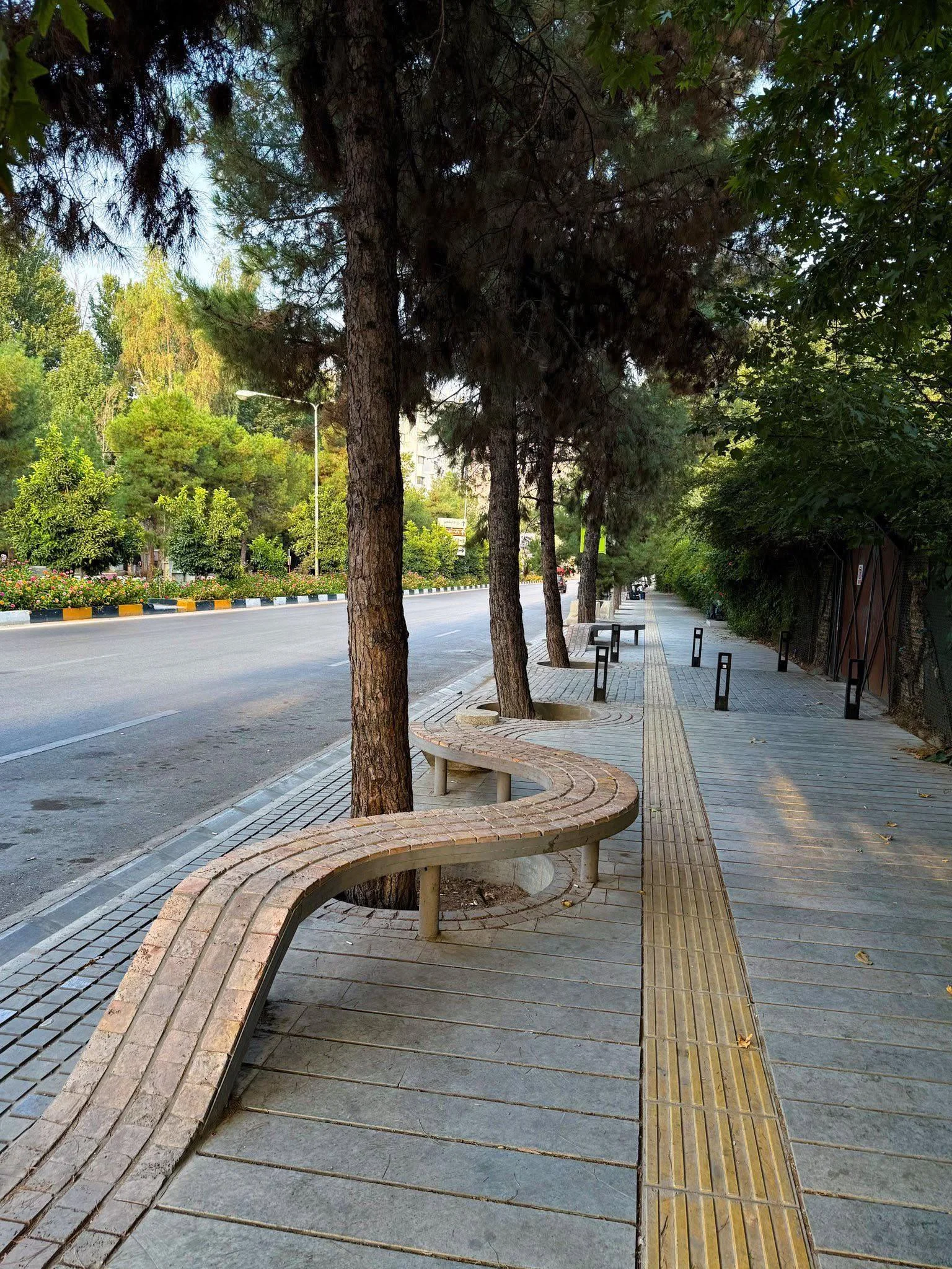 La panchina in mattoni che serpeggia tra i pini: muratura decorativa persiana come arredo urbano