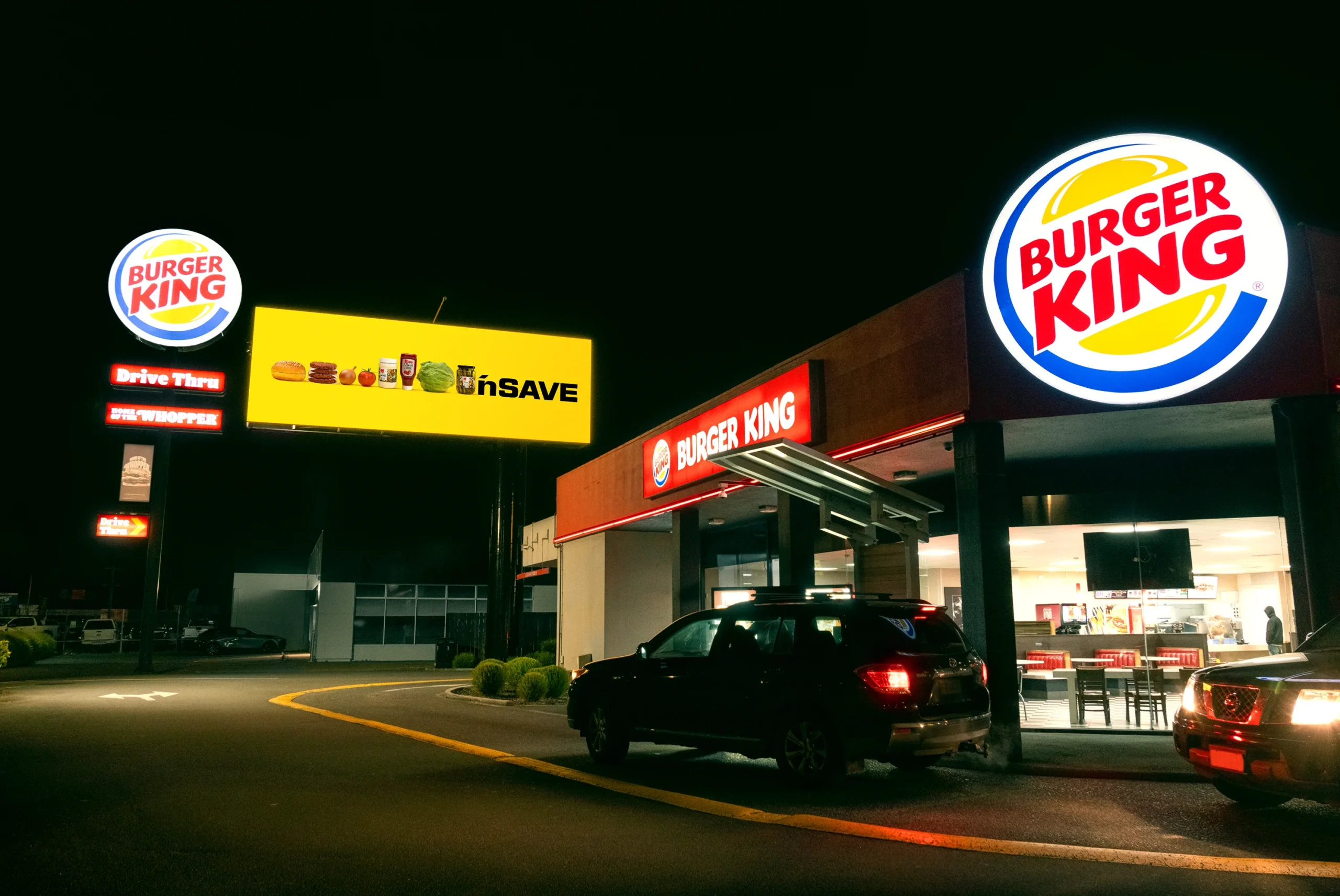 Pubblicità comparativa outdoor: il cartellone giallo che trasforma un marchio in un panino davanti al fast food